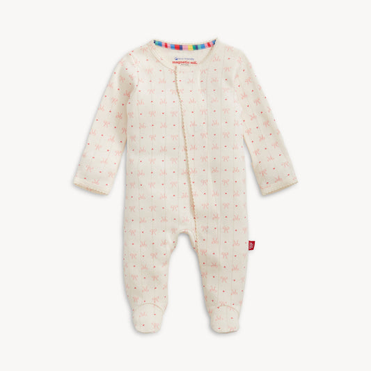 Pink hearts and bows on a pointelle knit baby one piece.