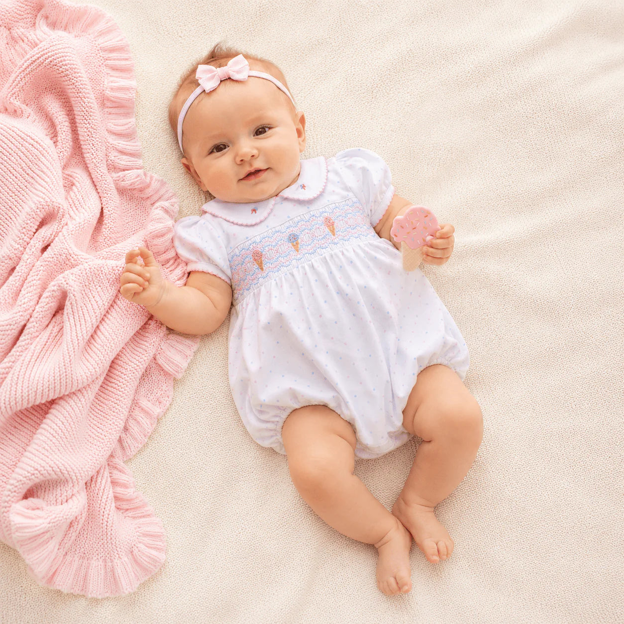 White short-sleeve smocked romper with pastel ice cream embroidery.