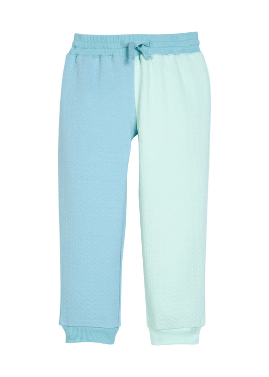 A pair of children's sweatpants in a split-color design, featuring light blue on the left leg and mint green on the right leg, with a matching drawstring waistband.