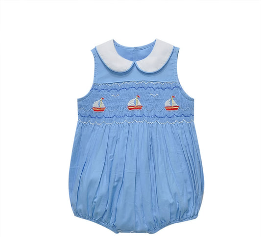 Light blue romper with a white collar and embroidered sailboats on smocking.