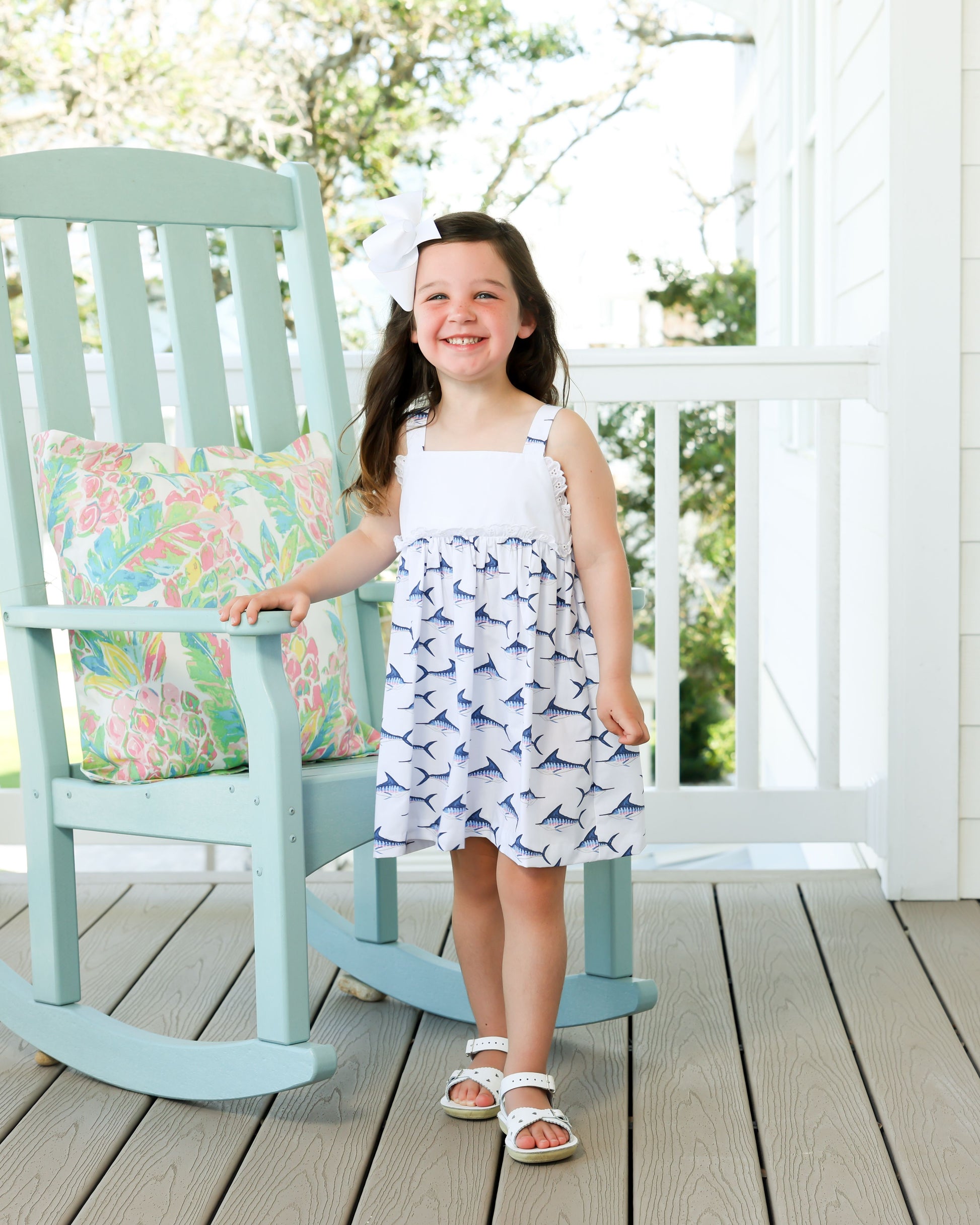 white dress with blue marlin design on bottom with white eyelet trim in middle 