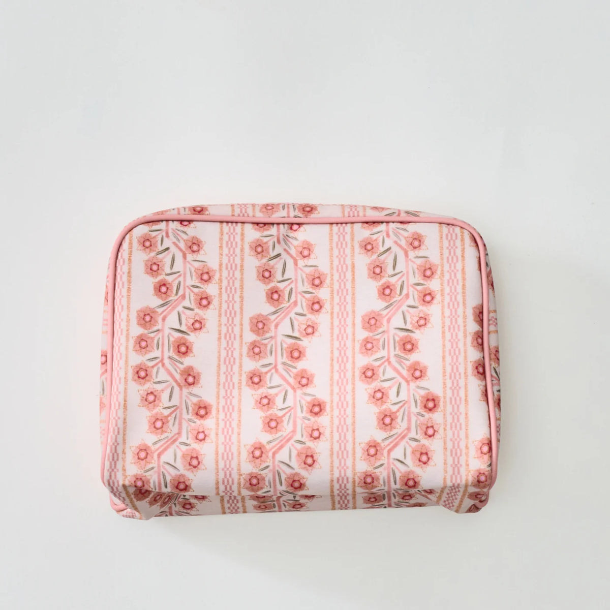 A rectangular zippered pouch with a pink and white floral pattern, photographed from above on a light gray background.