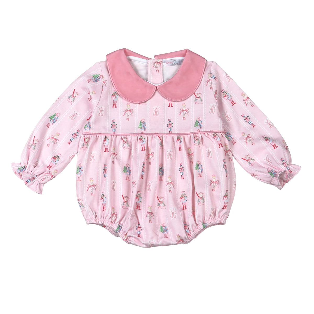 A pink long-sleeve baby romper with a Peter Pan collar, featuring an all-over nutcracker and tree print, set against a plain white background.