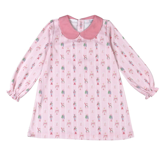 A pink long-sleeve baby dress with a Peter Pan collar, featuring an all-over print of small ballerinas and ballet shoes, displayed on a clean white background.