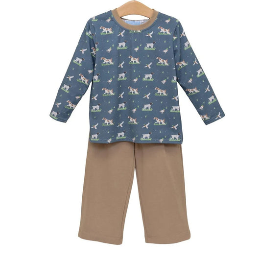 A two-piece children's set with a long-sleeve top in slate blue with an all-over print of dogs and birds and tan trim with matching solid tan pants.