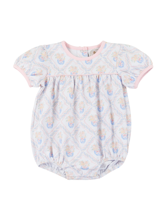 Baby girl bubble with floral pattern with pink piping around collar.