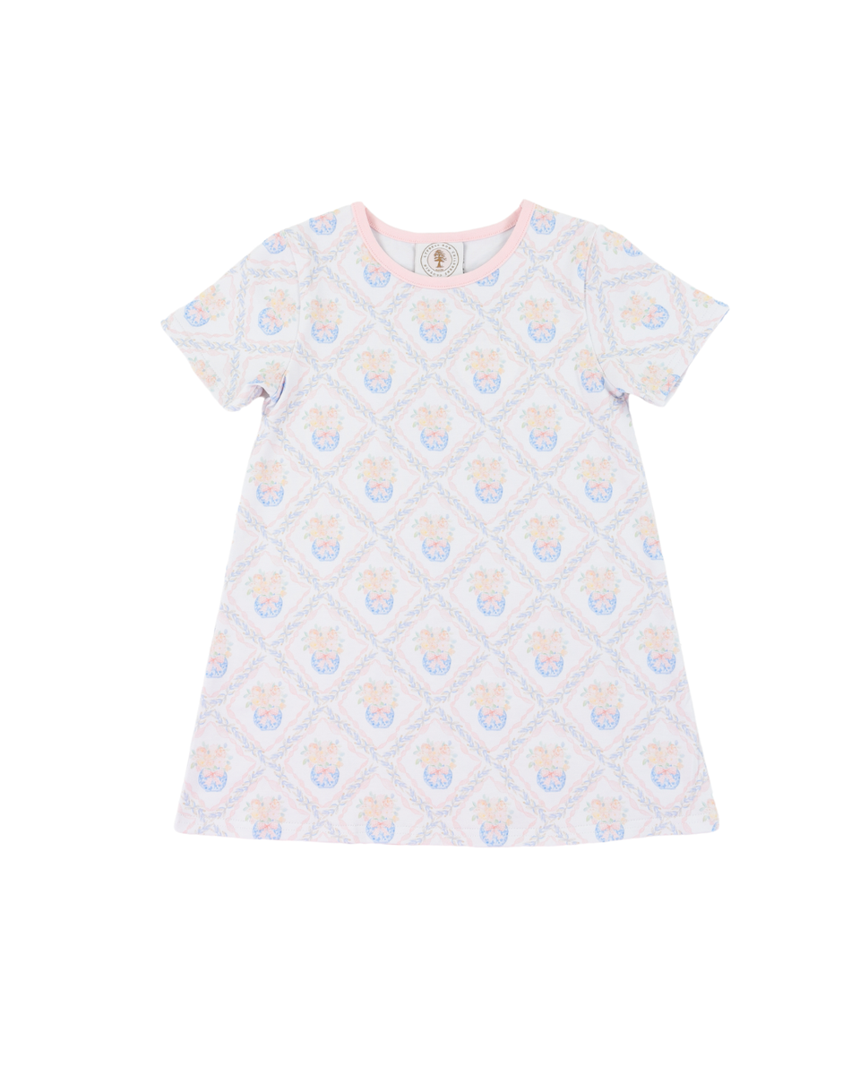 White dress with colorful floral  pattern with pink piping around neck.