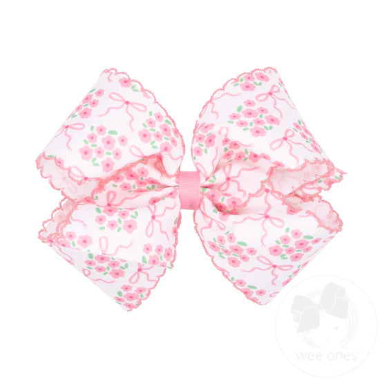 Light pink floral pattern and moonstitch edge on white hair bow.