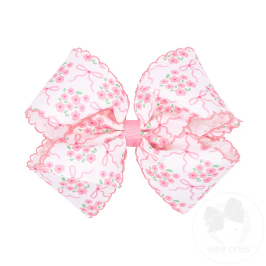 Light pink floral pattern and moonstitch edge on white hair bow.