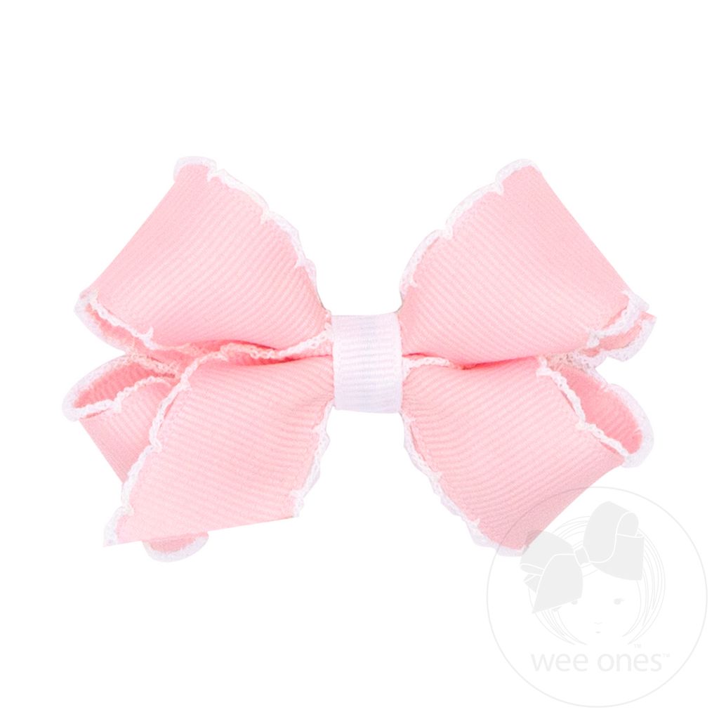 Pink hair bow with white moonstitch edging.