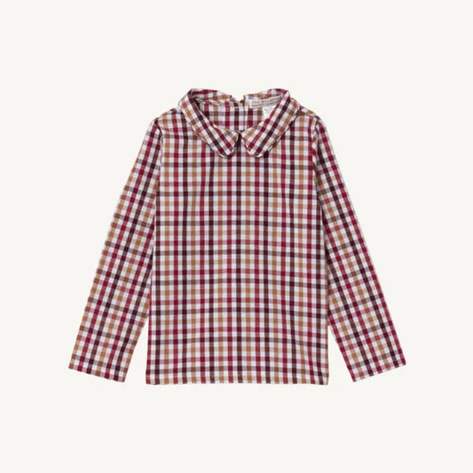 A long-sleeve collared shirt with a red, beige, and tan plaid pattern, displayed flat against a light cream background.