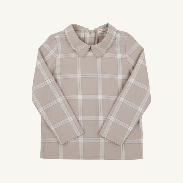 A long-sleeve collared shirt in a warm beige/tan color with a white windowpane plaid pattern, laid flat against a light cream background.