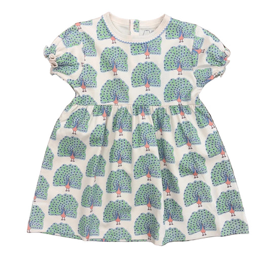 Short sleeve dress with blue, green and pink peacock design on a cream background.