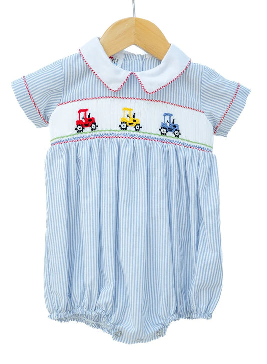 Baby romper with striped pattern and embroidered tractors on a hanger against a white background
