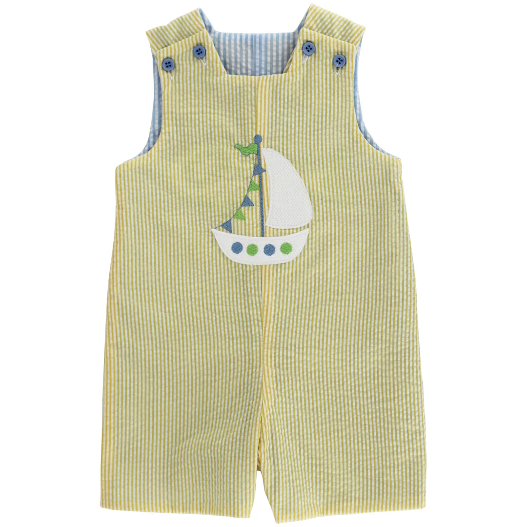 Yellow seersucker overalls with sailboat design on one side and alligator design on other side 