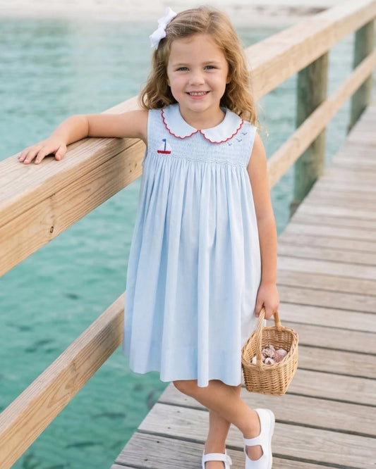 Light blue smocked dress with sailboat design and red scallop collar
