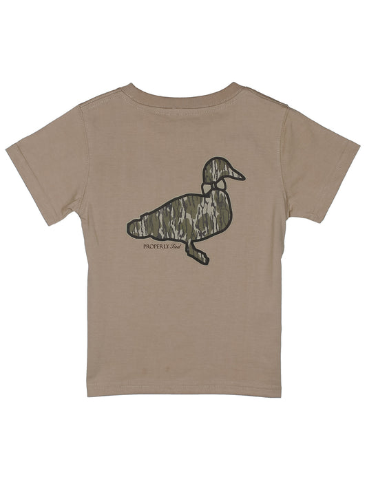 A kids' short-sleeve t-shirt in a warm tan or khaki color, shown from the back. The back features a large camouflage-patterned duck graphic with the brand name properly tied