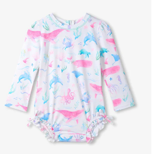 Rashguard swimsuite with pink and blue sea creatures on a white background.