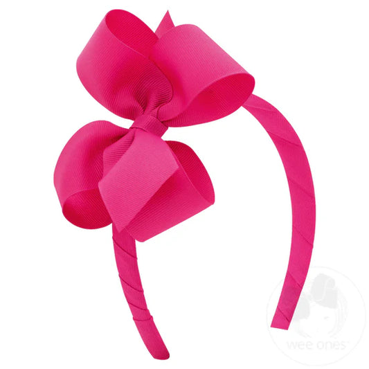 Bright pink bow on matching headband.