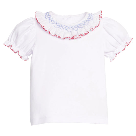 White blouse with smocked red and blue trim on a white background