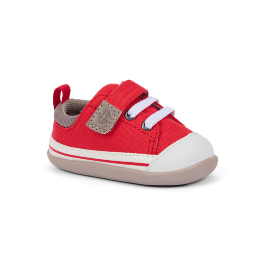 Red children's shoe with white laces on a white background