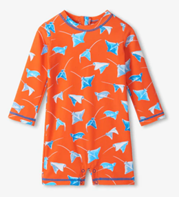 Boy's rashguard swimsuit with blue stingrays on an orange background.