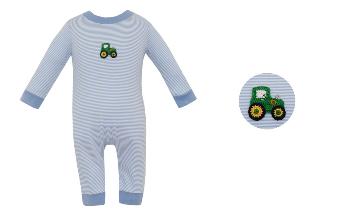 A baby long-sleeve footed romper in light blue and white stripes, featuring a green tractor graphic on the chest and a circular inset showing a close-up of the chest print.