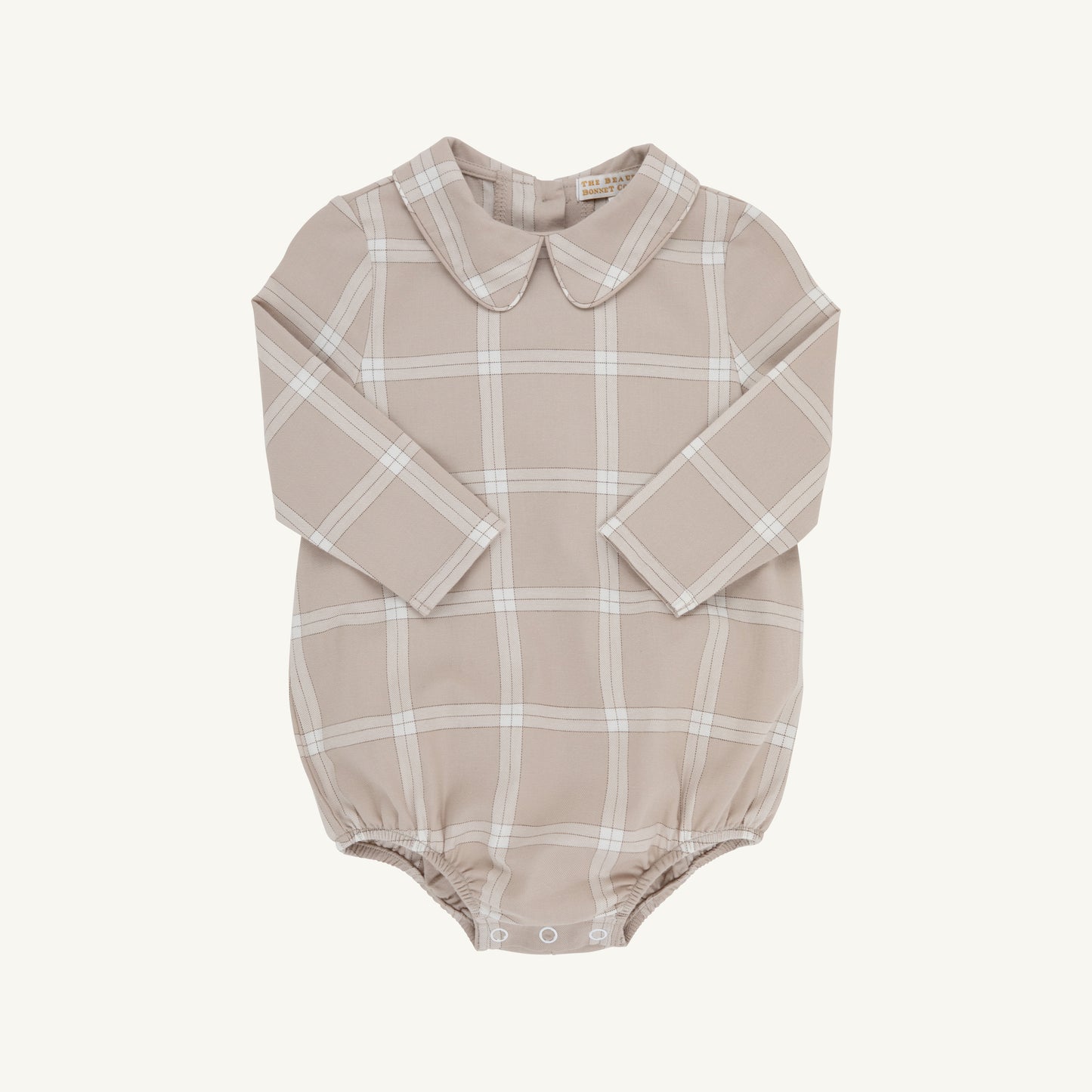 A long-sleeve baby romper in a dusty beige color with a white windowpane plaid pattern, featuring a Peter Pan collar and snap closures at the crotch.