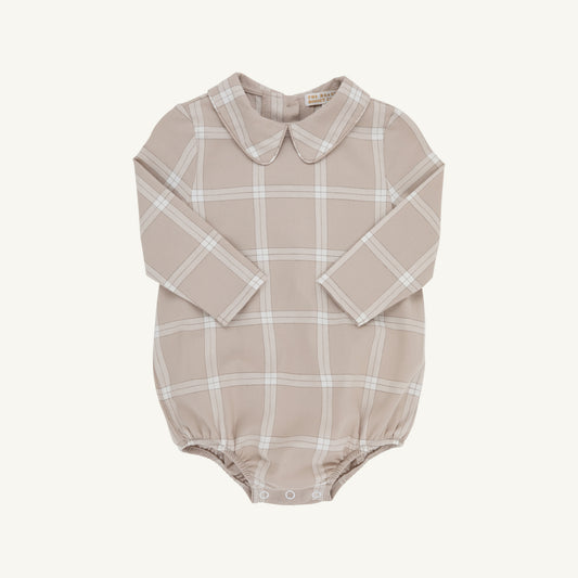 A long-sleeve baby romper in a dusty beige color with a white windowpane plaid pattern, featuring a Peter Pan collar and snap closures at the crotch.