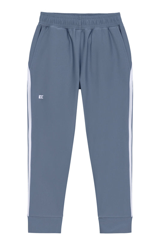A pair of slate blue sweatpants with white side stripes and a small white embroidered logo on the left thigh, shown against a plain white background.