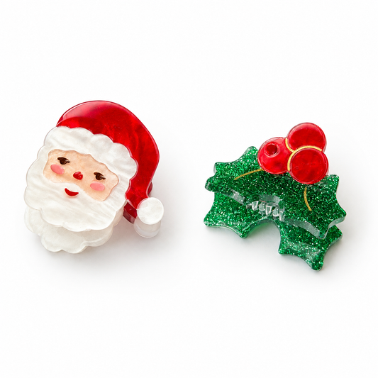 Two small Christmas-themed decorative items on a white background: a Santa Claus face and hat on the left, and a green glitter holly leaf with red berries on the right.