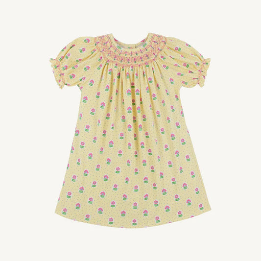 Yellow bishop smocked dress with green and pink flowers with pink smocked designs around the collar 
